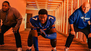 UF coaches Darnell Stapleton (left) and Rob Sale (right) with OL Roderick Kearney.